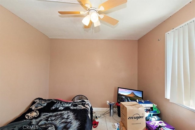 bedroom featuring a ceiling fan, baseboards, and light tile patterned floors