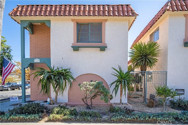 mediterranean / spanish-style house featuring a tiled roof and stucco siding