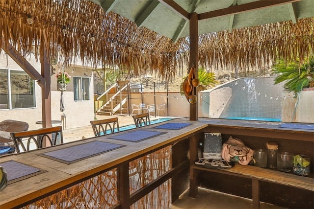 wooden terrace with a patio, stairway, and fence