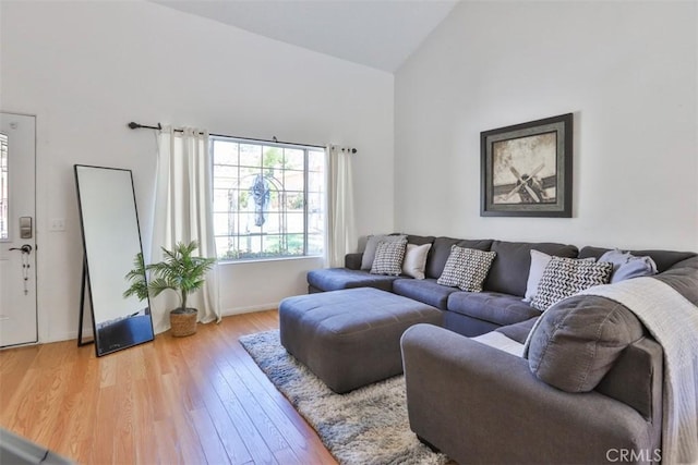 living room with high vaulted ceiling and wood finished floors