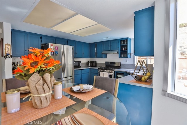 kitchen featuring stainless steel appliances, light countertops, and blue cabinetry