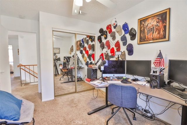 office area with ceiling fan, a textured ceiling, and light colored carpet