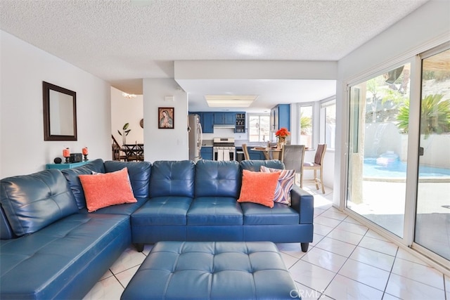 living room with a textured ceiling and light tile patterned floors