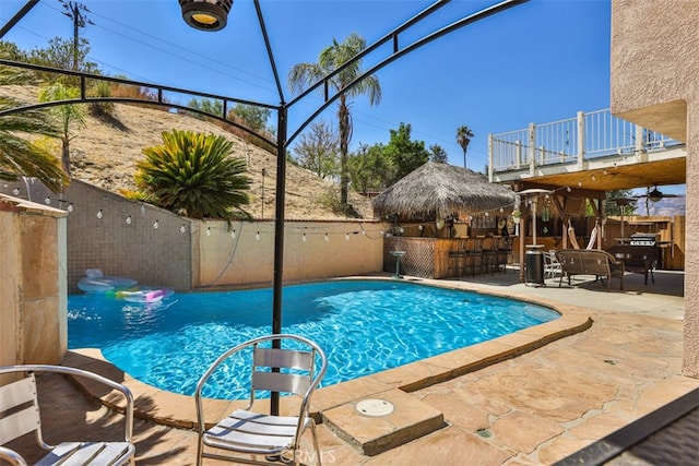 view of swimming pool featuring a fenced in pool, a patio area, outdoor dry bar, and a fenced backyard