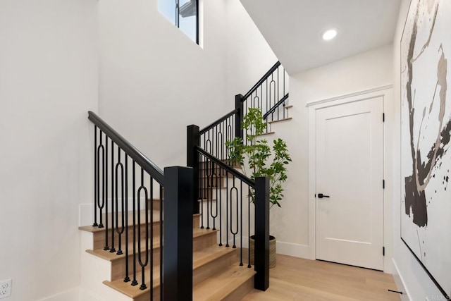 foyer entrance featuring light wood-type flooring, stairway, and recessed lighting