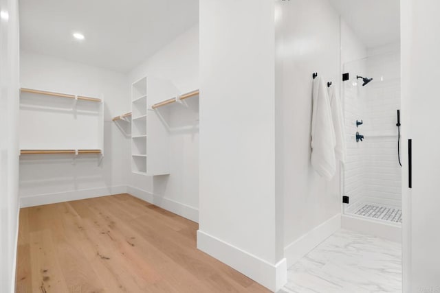 walk in closet with marble finish floor