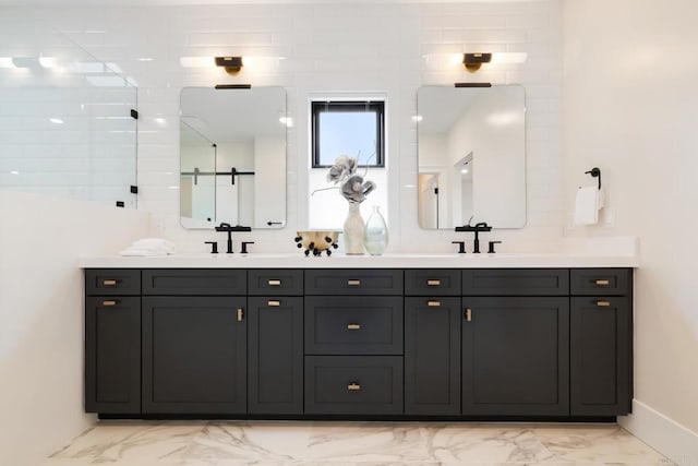 bathroom with marble finish floor, double vanity, and a sink