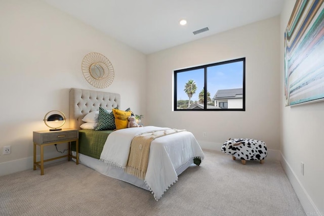 bedroom with visible vents, light carpet, and baseboards