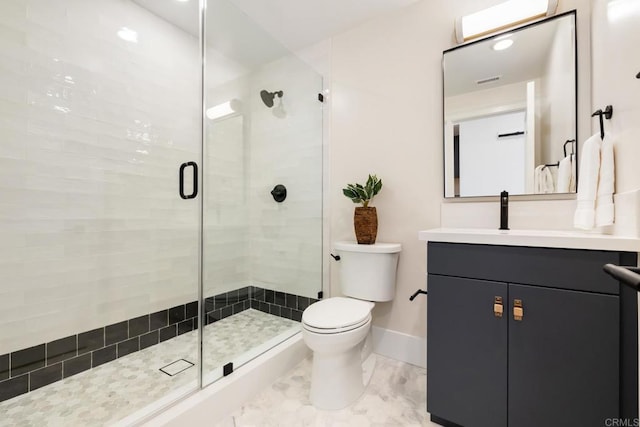 bathroom featuring toilet, a stall shower, baseboards, and vanity