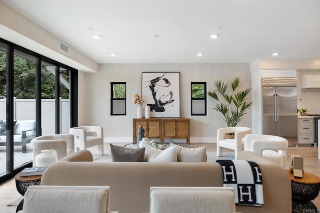 living room with baseboards, recessed lighting, visible vents, and wallpapered walls