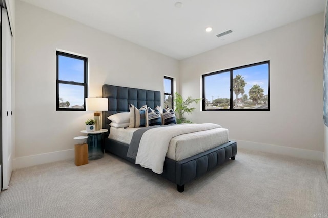 bedroom featuring light colored carpet, visible vents, and baseboards