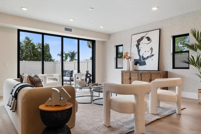 living room featuring recessed lighting, visible vents, light wood-style flooring, baseboards, and wallpapered walls