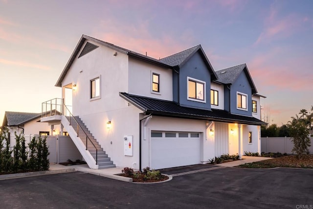 modern inspired farmhouse featuring stairway, a standing seam roof, metal roof, fence, and driveway