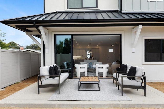 view of patio / terrace featuring outdoor lounge area, fence, and an attached garage