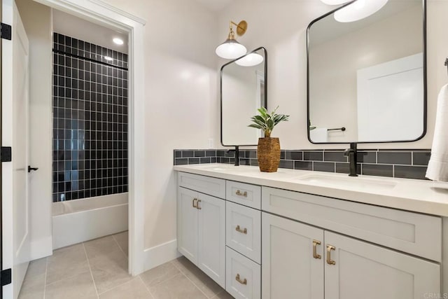 bathroom with bathing tub / shower combination, double vanity, tasteful backsplash, a sink, and tile patterned floors