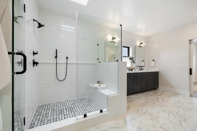 bathroom with marble finish floor, vanity, baseboards, and a stall shower