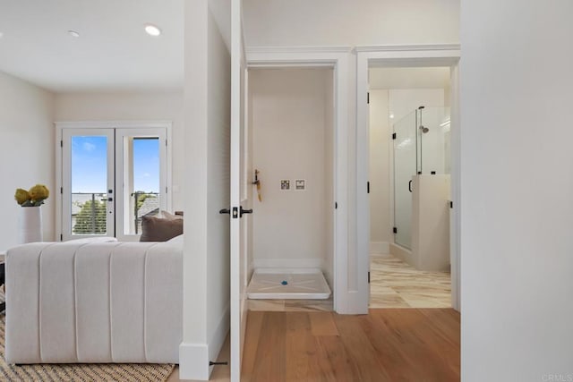 hall featuring light wood-style flooring and baseboards