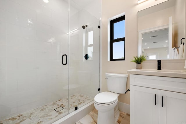 full bath featuring a stall shower, baseboards, vanity, and toilet