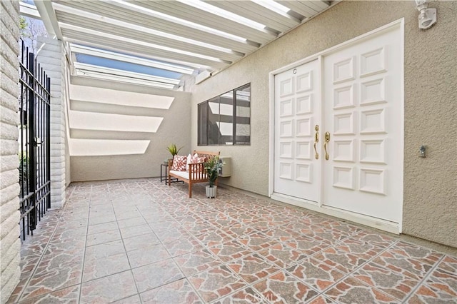 doorway to property featuring a patio area and stucco siding