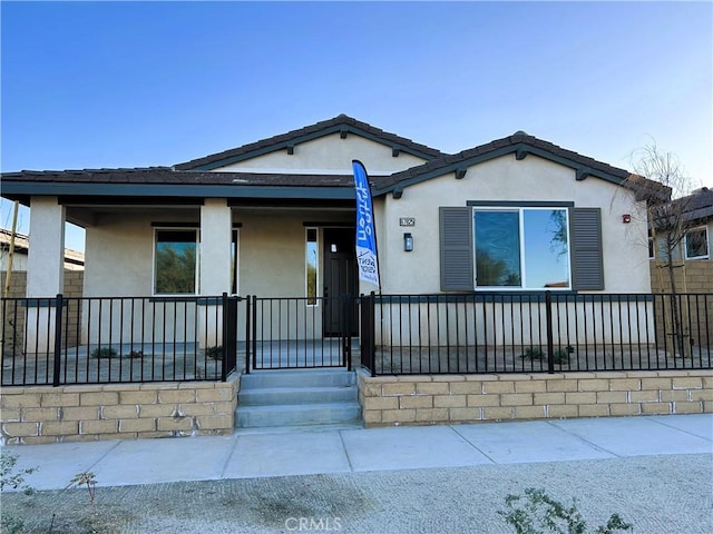 view of front facade featuring covered porch and stucco siding