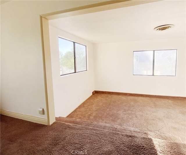 unfurnished room with carpet floors and baseboards