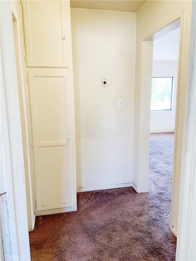 hallway with carpet flooring and baseboards