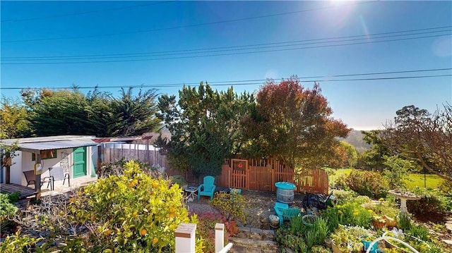 view of yard with fence and an outdoor structure