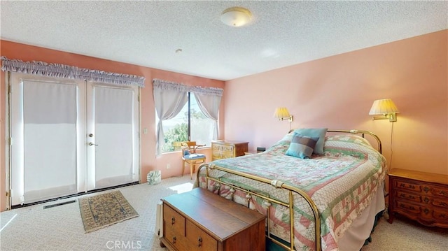 bedroom with a textured ceiling and light colored carpet