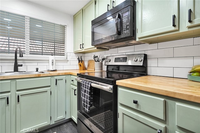 kitchen featuring stainless steel electric range oven, butcher block countertops, a sink, black microwave, and green cabinetry