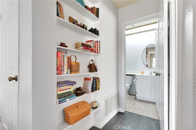 corridor featuring visible vents and baseboards