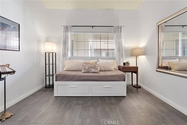 bedroom with dark wood-style flooring and baseboards