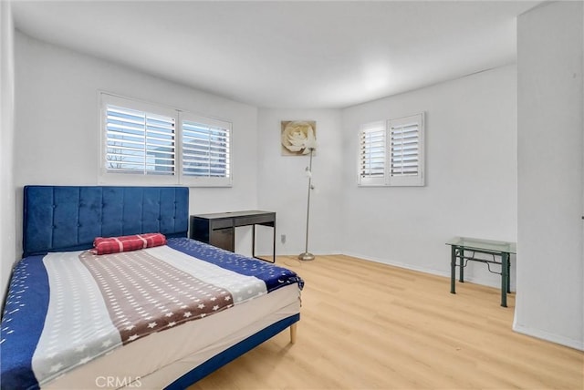 bedroom featuring baseboards and wood finished floors