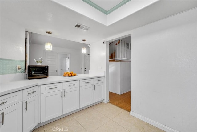 kitchen featuring visible vents, white cabinets, hanging light fixtures, light countertops, and light tile patterned flooring