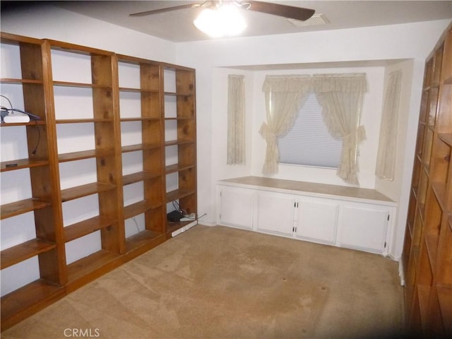 interior space with a ceiling fan, light colored carpet, and visible vents