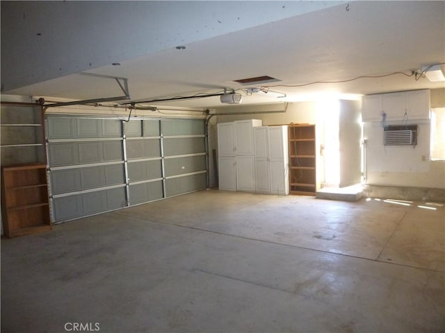 garage with a wall unit AC and a garage door opener