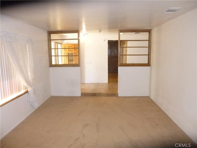 carpeted spare room featuring visible vents