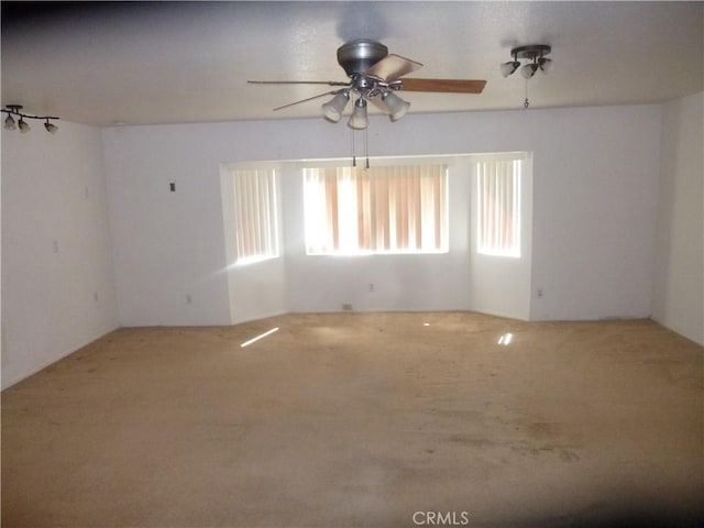 carpeted spare room featuring ceiling fan