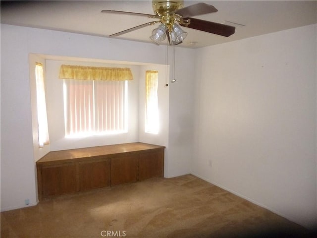 carpeted spare room featuring a ceiling fan