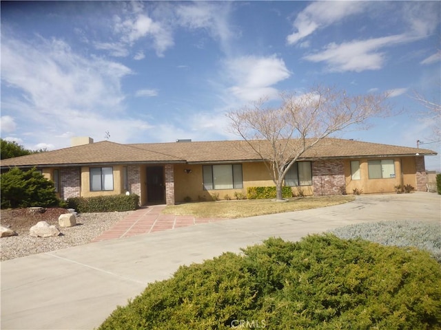 single story home with driveway and brick siding