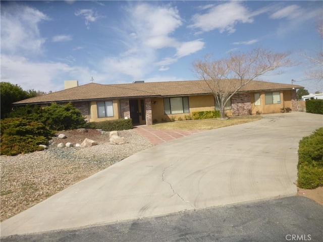 ranch-style house featuring concrete driveway