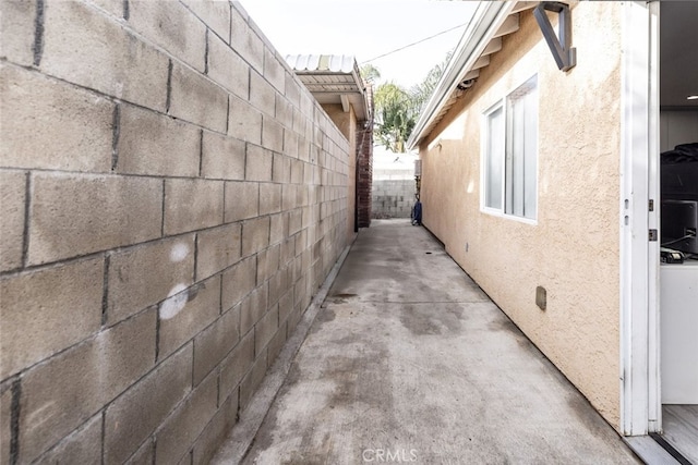 view of side of property featuring a patio area, fence, and stucco siding