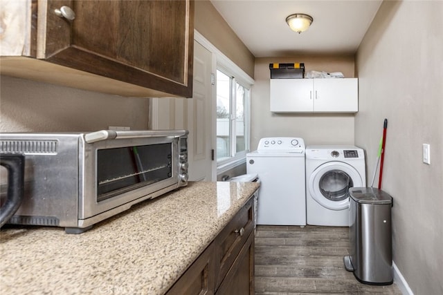 clothes washing area featuring dark wood-style flooring, a toaster, washer and clothes dryer, laundry area, and baseboards