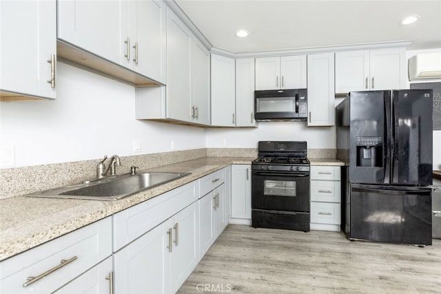 kitchen with black appliances, a sink, and white cabinets