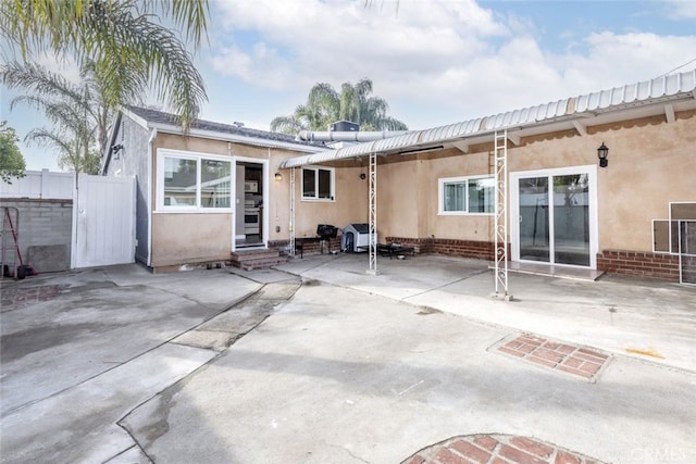 rear view of house featuring entry steps, a patio area, and stucco siding