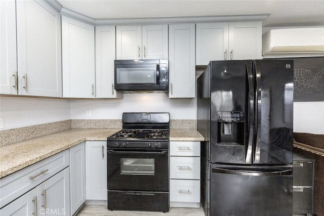 kitchen featuring light stone counters, an AC wall unit, and black appliances