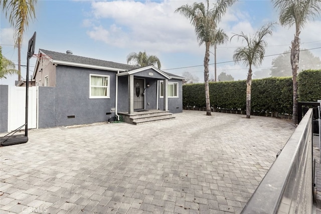 view of front of house featuring crawl space, fence, and stucco siding