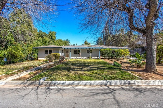 ranch-style house featuring stucco siding and a front yard