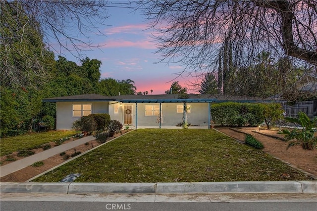 view of front of property featuring a yard and stucco siding