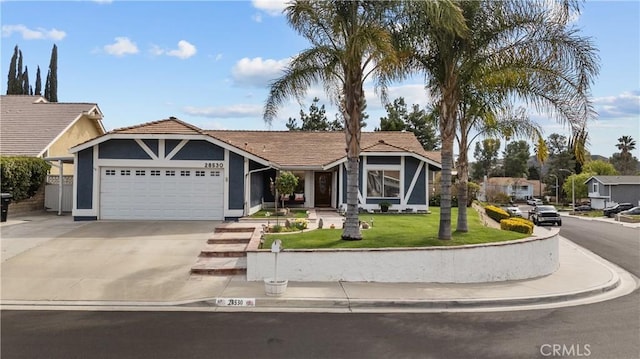 view of front of house featuring a garage, driveway, and a front lawn