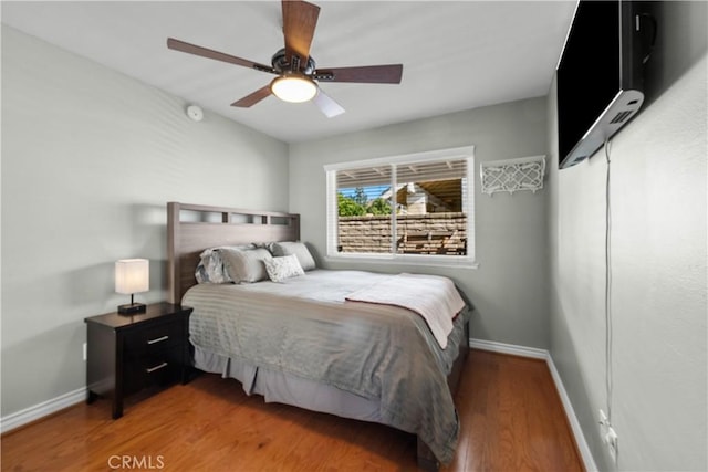 bedroom featuring ceiling fan, baseboards, and wood finished floors